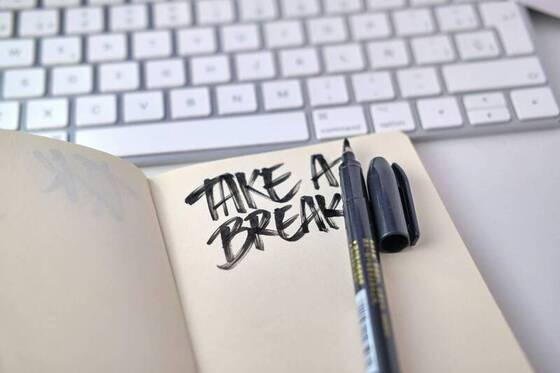 A notebook reading 'Take a break' beside a keyboard